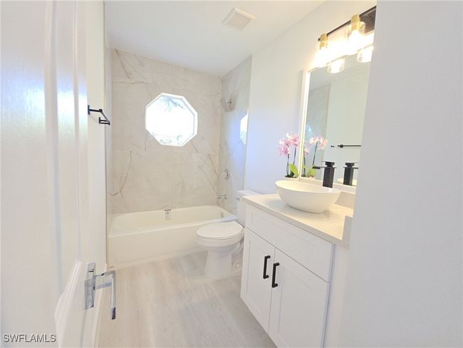 Bathroom with wood finished floors, vanity, shower / tub combination, and toilet | Image 31