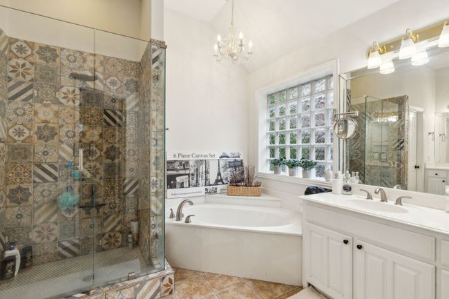 Full bath with an inviting chandelier, tile patterned flooring, a stall shower, and a bath | Image 20
