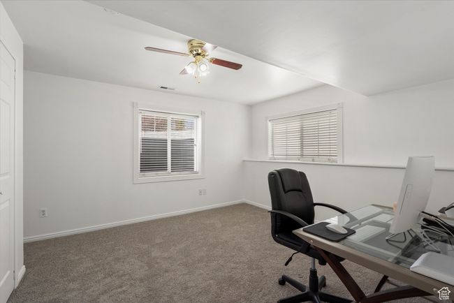 Carpeted home office with a ceiling fan, baseboards, and a healthy amount of sunlight | Image 30