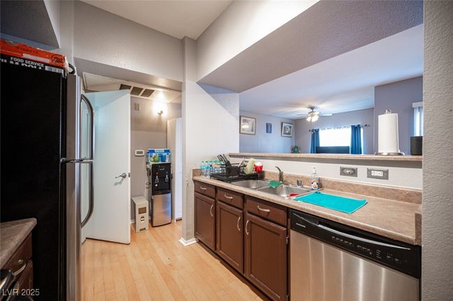 Kitchen with a sink, light countertops, appliances with stainless steel finishes, ceiling fan, and light wood-style flooring | Image 17