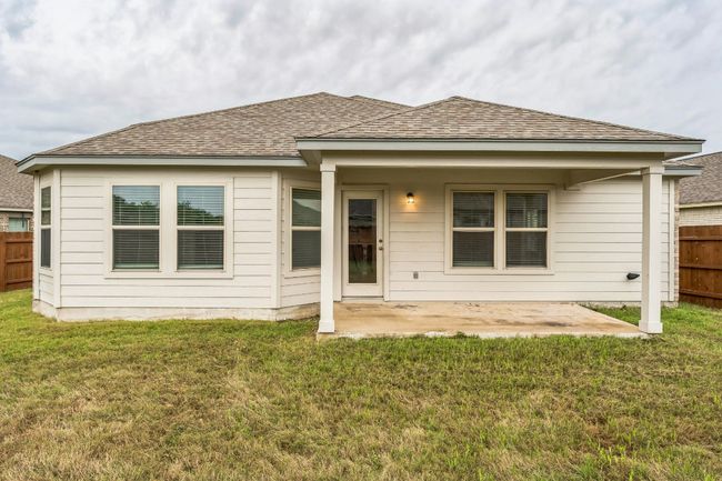 Rear view of house with a fenced backyard, a patio area, and roof with shingles | Image 16