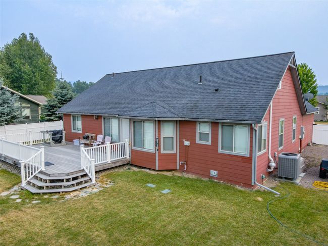 Rear view of house with roof with shingles, central AC, fence, and a lawn | Image 22