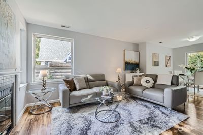 living room is just off the main entry and has a cozy gas-log starter wood burning fireplace as well as west and south facing windows | Image 3