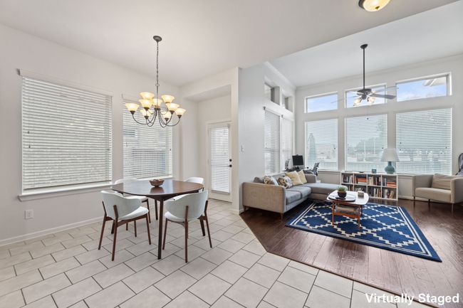 Tiled dining room with a chandelier, a ceiling fan, and baseboards | Image 13