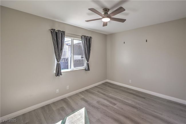 Spare room featuring ceiling fan, baseboards, and wood finished floors | Image 29