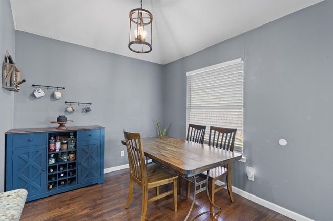 Dining room with dark wood-style floors, lofted ceiling, and baseboards | Image 12