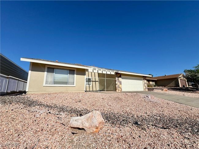 View of front facade with a garage, driveway, stone siding, and stucco siding | Image 7