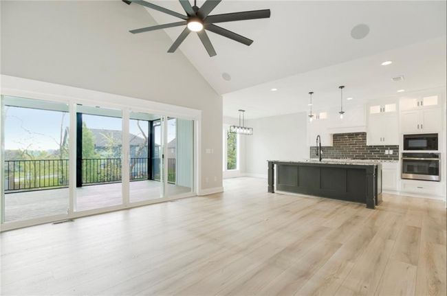 Unfurnished living room featuring high vaulted ceiling, recessed lighting, ceiling fan, light wood-style floors, and baseboards | Image 6