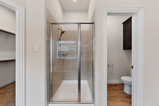 Bathroom featuring a shower stall, a spacious closet, and wood finished floors | Image 21