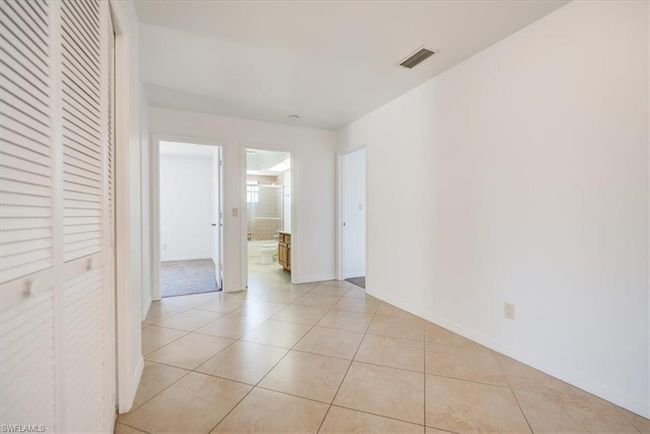 Empty room with baseboards, visible vents, and light tile patterned floors | Image 18