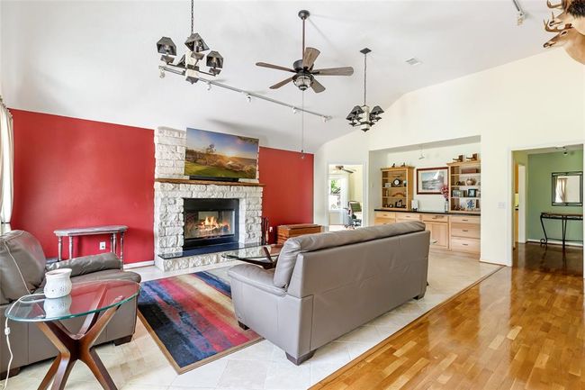 Family room with wood burning white limestone fireplace | Image 5