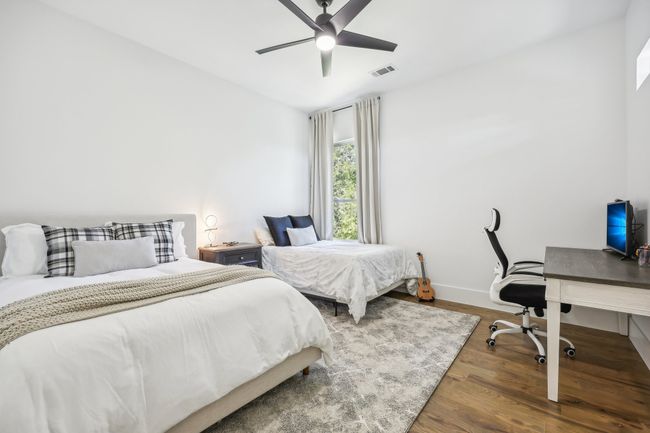 Bedroom featuring wood finished floors, an office area, and a ceiling fan | Image 29