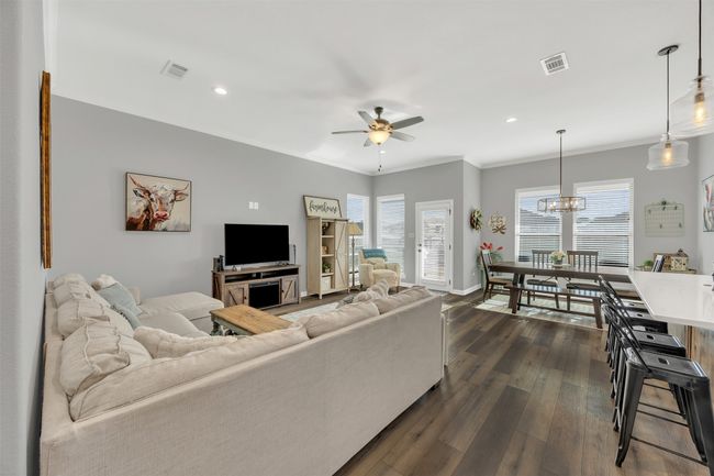 Living room with a wealth of natural light, visible vents, and dark wood-style flooring | Image 9