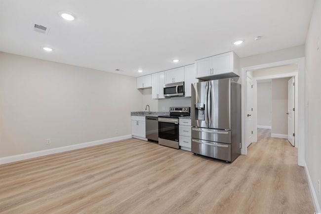 Kitchen with stainless steel appliances, baseboards, white cabinets, a sink, and recessed lighting | Image 9