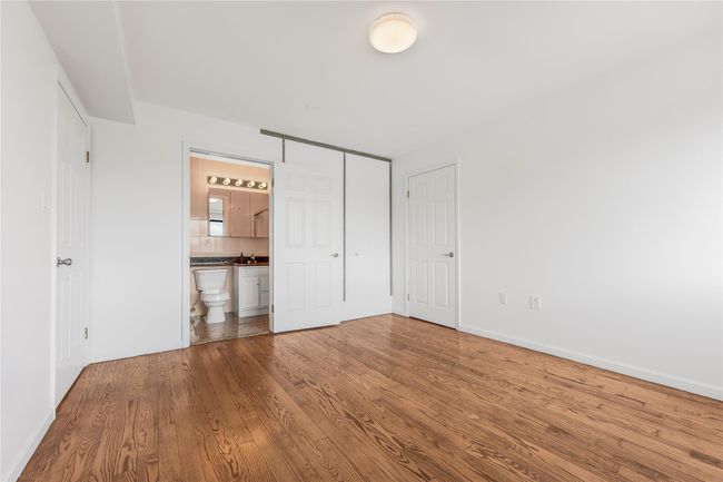 Unfurnished bedroom with wood finished floors, ensuite bath, and a closet | Image 24
