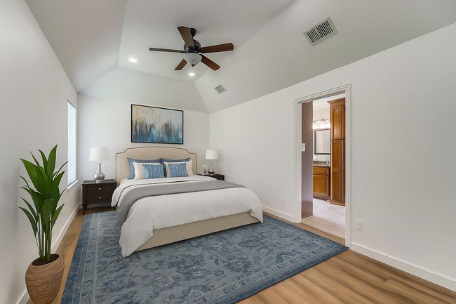 Bedroom featuring vaulted ceiling, light wood-style flooring, ensuite bathroom, and ceiling fan | Image 5