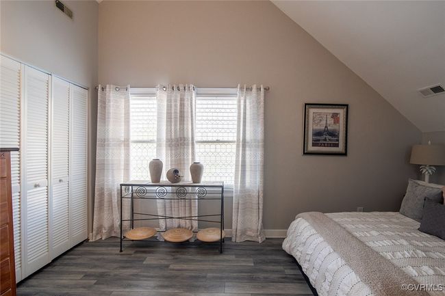 Bedroom with visible vents, high vaulted ceiling, and wood finished floors | Image 24