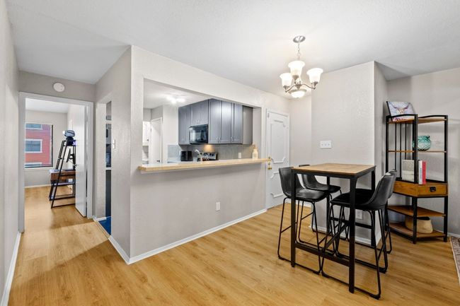 A spacious dining area is perfect for a 4-person table and is centered by a chandelier. | Image 7