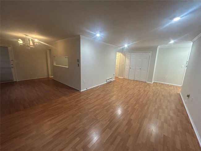 Spare room featuring crown molding, wood finished floors, a chandelier, and recessed lighting | Image 5