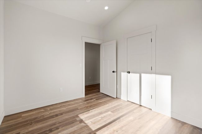 Unfurnished bedroom with recessed lighting, baseboards, wood finished floors, and vaulted ceiling | Image 19