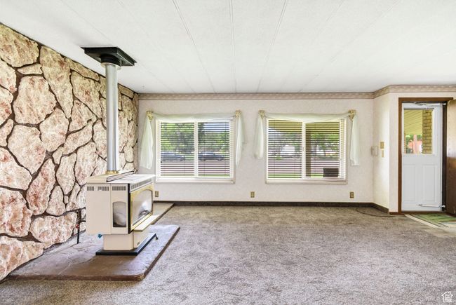 Unfurnished living room with a gas stove and carpet | Image 8