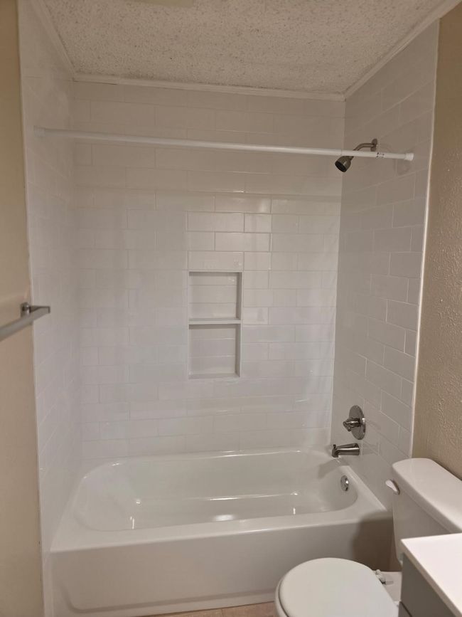 Bathroom with shower / bathtub combination, vanity, a textured wall, and a textured ceiling | Image 8