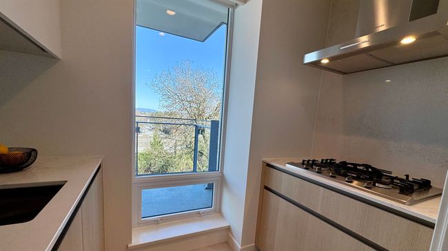 Kitchen featuring exhaust hood, a sink, stainless steel gas stovetop, modern cabinets, and light countertops | Image 5
