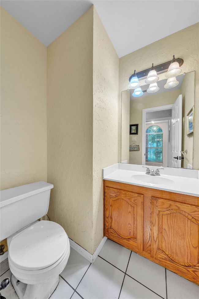 Half bath featuring a textured wall, vanity, and tile patterned flooring | Image 20