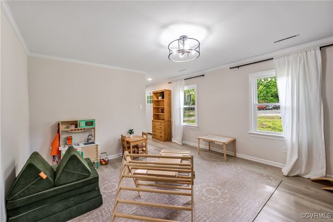 living room featuring light wood-type flooring, crown molding, and baseboards | Image 4
