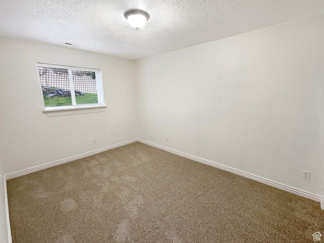 Carpeted spare room with baseboards, a textured ceiling, and visible vents | Image 18