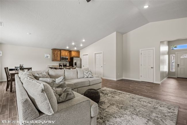 Living room with vaulted ceiling, wood finished floors, baseboards, and recessed lighting | Image 22