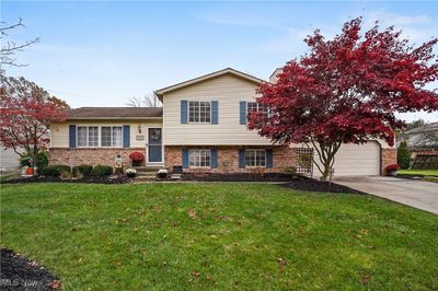 Tri-level home with a front yard and a garage | Image 1