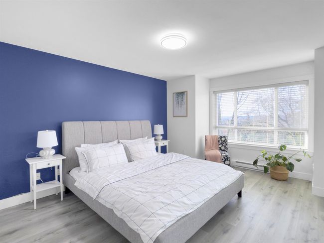 Bedroom featuring a baseboard radiator, baseboards, and wood finished floors | Image 20