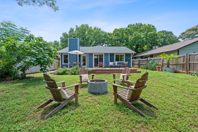 Rear view of property with an outdoor fire pit, a fenced backyard, a chimney, and a wooden deck | Image 38