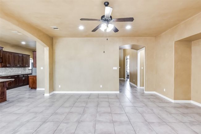 Unfurnished living room with arched walkways, ceiling fan, and recessed lighting | Image 11
