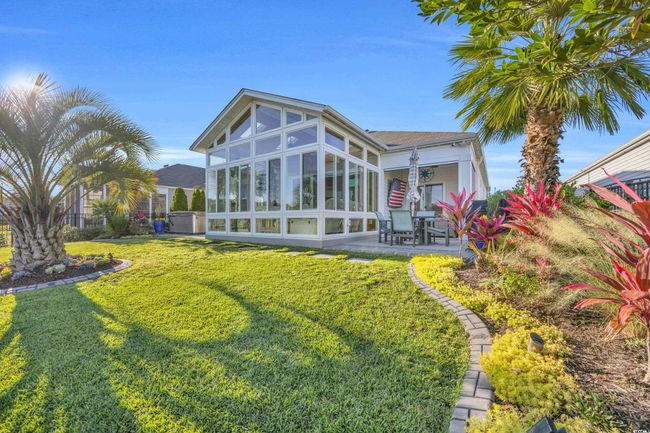 Rear view of house featuring a sunroom, a lawn, and a patio area | Image 29