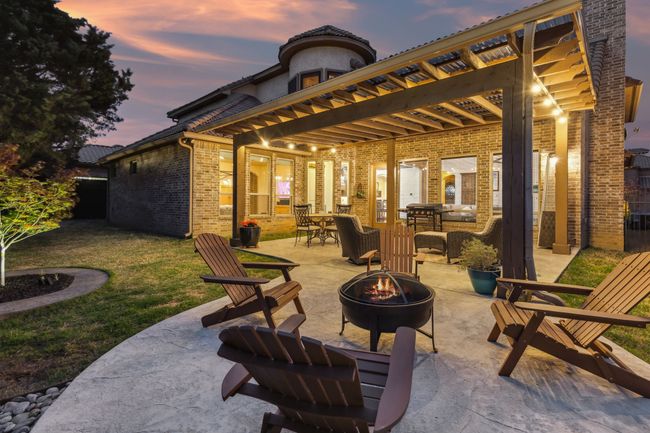 Patio terrace at dusk with an outdoor fire pit, a yard, and outdoor dining space | Image 33
