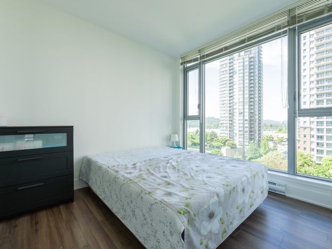 Bedroom with multiple windows, dark wood-type flooring, and a city view | Image 11