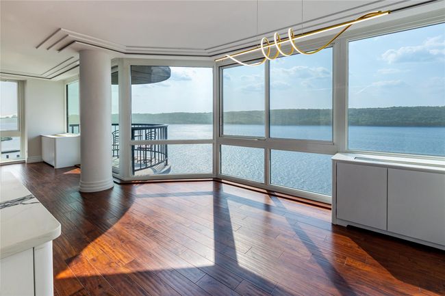 Unfurnished sunroom with plenty of natural light, a water view, and a chandelier | Image 5