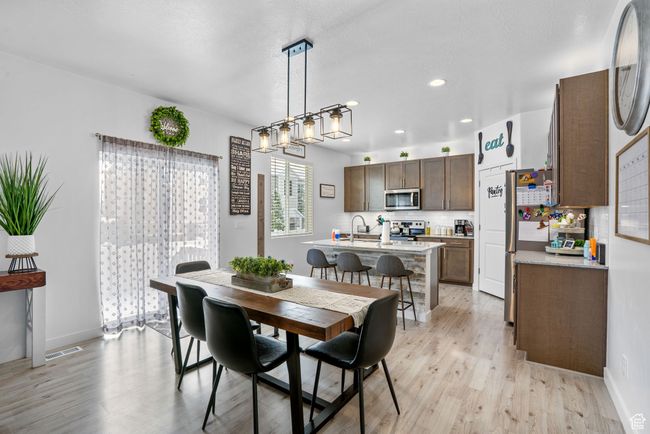Dining area featuring baseboards, visible vents, light wood finished floors, and recessed lighting | Image 10