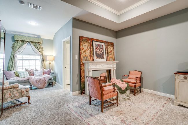 Living area with baseboards, visible vents, crown molding, and light carpet | Image 4