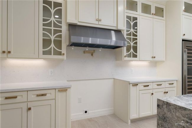 Stainless steel appliances include a French-door refrigerator, built-in wine cooler, and commercial-grade range hood. | Image 11