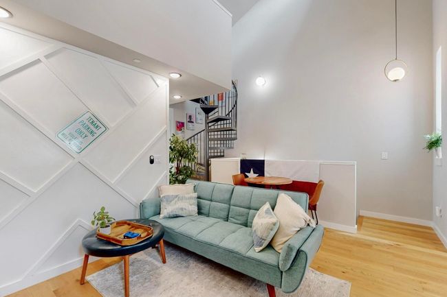 Living area featuring stairway, light wood-style floors, baseboards, and a high ceiling | Image 12