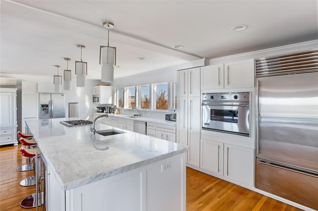Kitchen with appliances with stainless steel finishes, light wood-style floors, white cabinets, and a sink | Image 5