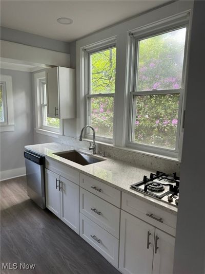 Kitchen with dishwasher, plenty of natural light, white cabinetry, and sink | Image 3