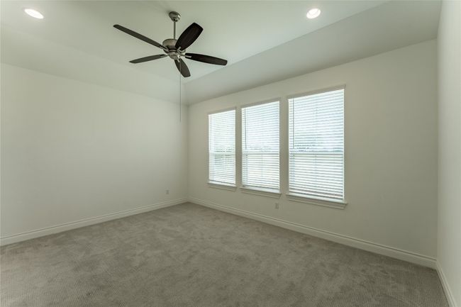 Carpeted empty room featuring a ceiling fan, recessed lighting, and lofted ceiling | Image 23