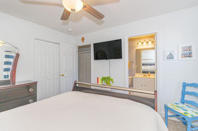 Bedroom featuring ceiling fan, ensuite bathroom, a closet, and a textured ceiling | Image 22
