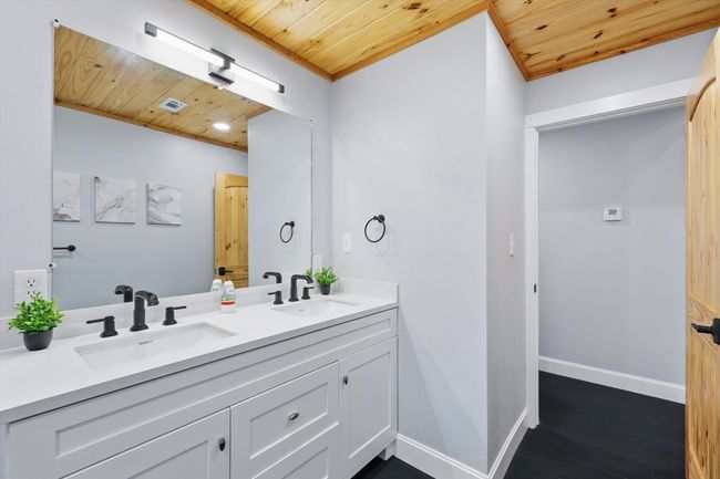 Bathroom featuring wood ceiling, baseboards, a sink, and wood finished floors | Image 29