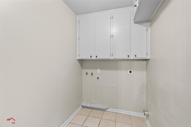 Laundry room featuring cabinet space, baseboards, electric dryer hookup, light tile patterned flooring, and hookup for a washing machine | Image 9
