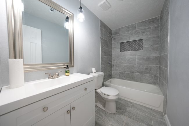 Full bath with toilet, bathtub / shower combination, and vanity | Image 12